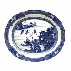 Late 18th/early 19th century Chinese export oval meat plate decorated in blue and white with a river landscape within a geometric border with small landscape panels W41cm
