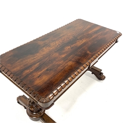 Victorian rosewood library table, the rectangular top with castellated edge and floral carved rounded corners over two frieze drawers, raised on two lobe carved end supports leading to platform base, floral scroll carved feet and brass castors, 128cm x 62cm, H74cm