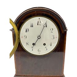 An Edwardian mahogany mantle clock with a break arch top, inlaid satinwood stringing and banding, case on a moulded plinth raised on four bun feet, with a French eight-day movement striking the hours and half hours on a coiled gong,  square movement plates stamped “B.T.G Medaille d’or”, six-inch enamel dial with upright Arabic numerals and minute markers, quarter hours in red Arabic’s, with steel moon hands, cast brass dial bezel with a convex glass, brass case door with pierced sound fret.  With pendulum and key.  