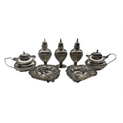 Late Victorian silver condiment set comprising three vase shape pepperettes and a pair of mustard pots Birmingham 1897/8 and a pair of small heart shape silver sweetmeat dishes 