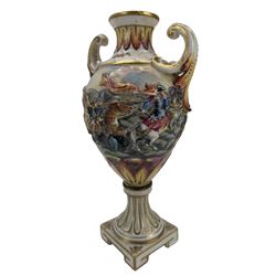 Continental porcelain vase and cover, decorated in the style of Augusts Rex, with alternating panels of courting couples and floral sprays on black ground, H24cm, together with a Capodimonte twin handled vase, decorated in relief with battle scenes (2)