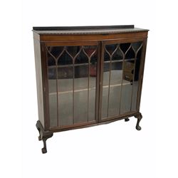 Early 20th century mahogany bow front display cabinet, with raised back over tracery glazed doors enclosing two adjustable shelves, raised on ball and claw supports (W123cm, H128cm, D36cm)