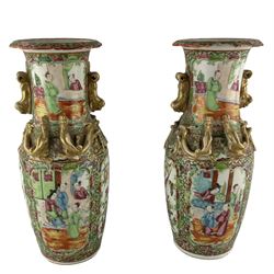 Pair of 19th century Chinese Canton Famille Rose vases, each hand painted with panels enclosing attendants and exotic birds, all reserved on a gilt-ground of dense lotus scrolls, with applied Dog of Fo handles and relief motifs to the necks, H26cm