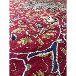 Persian rug with overall floral motifs on a red field and navy border 290cm x 400cm