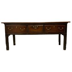 George III country oak dresser base, rectangular top over panelled sides, fitted with three drawers, and raised on fluted supports