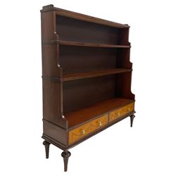 Regency design mahogany waterfall bookcase, the raised gallery over three graduating open shelves flanked by undulating uprights, the base fitted with two crossbanded satinwood fronted drawers, the drawers decorated with inlaid garlands and ebony and boxwood stringing, raised on tapered tulip feet with ring turn