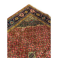 Persian Arrak red ground rug, the field with central medallion surrounded by Heratti motifs, matching spandrels, multi-band border decorated with stylised plant motifs and flower heads