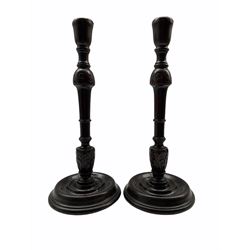 Pair of 19th century mahogany candlesticks with leaf carved stems and circular bases H34cm