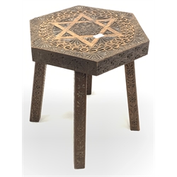Teak hexagonal table, the top carved with star of David and floral embellishment, raised on four chamfered and splayed supports with further stylised floral carvings, 50cm x 43cm, H48cm