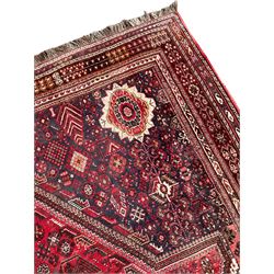 Old Persian rug, red and blue ground with triple lozenge medallions, the field decorated all-over with small stylised motifs, the outer border decorated with Boteh motifs