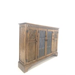 Reprodux oak cupboard bookcase, with lunette carved frieze over lead glazed door to centre and two cupboards, each enclosing two shelves, W135cm, H100cm, D29cm