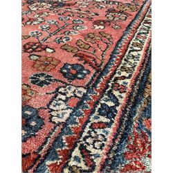 Persian rug, decorated with plant motifs on a red field, surrounded by multiple border 110cm x 199cm