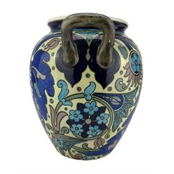 Burmantofts Faience twin-handled Anglo-Persian vase, designed by Leonard King, of ovoid form with applied loop handles and painted with stylized flowers and foliage against a blue and yellow ground, impressed factory marks no. 69, incised D.230, 1666 and artists monogram LK, H24.5cm 