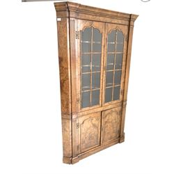 George II style figured walnut floor standing corner cabinet, two glazed doors enclosing three shaped shelves, with fluted pilasters and canted corners, two doors under, raised on skirted base W117cm, H189cm
