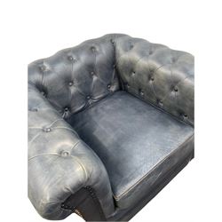 Chesterfield chair, upholstered in blue leather with buttoned back and arms, raised on turned supports 