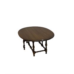 Ercol - drop leaf table, the circular top over gate leg action, raised on turned supports W43cm, H50cm, D106cm 